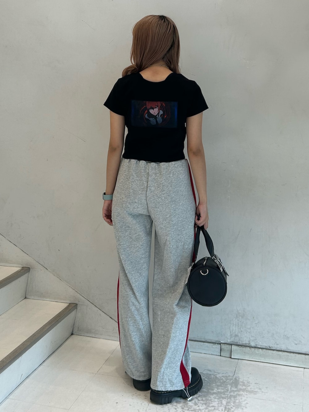 ブラック系のTシャツ/カットソー、グレー系のスウェットパンツ、ブラック系のボストンバッグを着用したレディースの春コーディネートの3枚目の写真