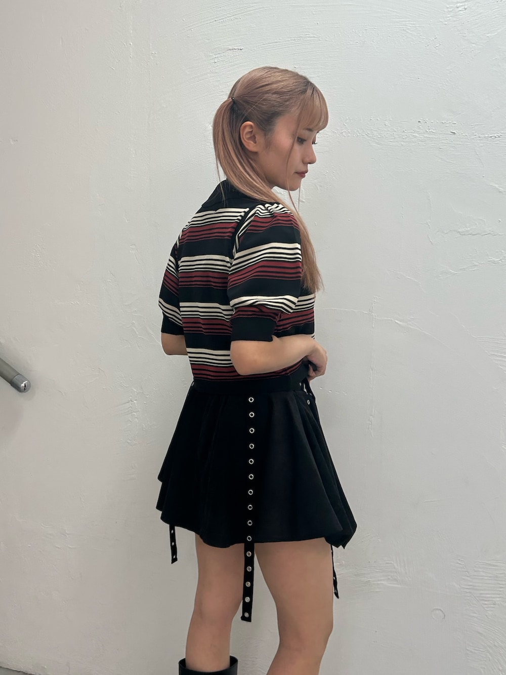 ブラック系のニット/セーター、ブラック系のスカート、ブラック系のブーツを着用したレディースの春コーディネートの5枚目の写真