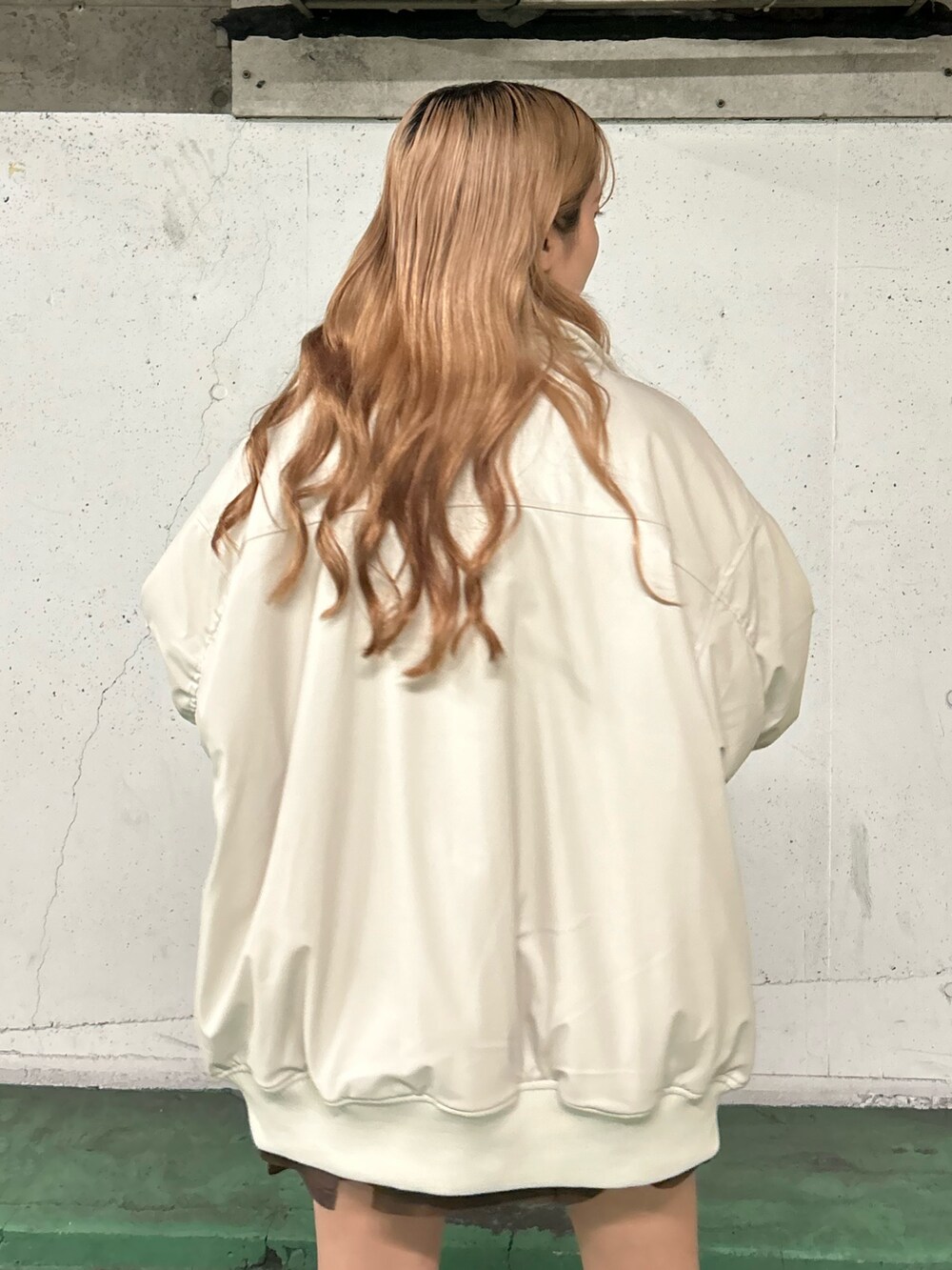 ホワイト系のブルゾン、レッド系のTシャツ/カットソー、ブラウン系のスカートを着用したレディースの秋コーディネートの6枚目の写真