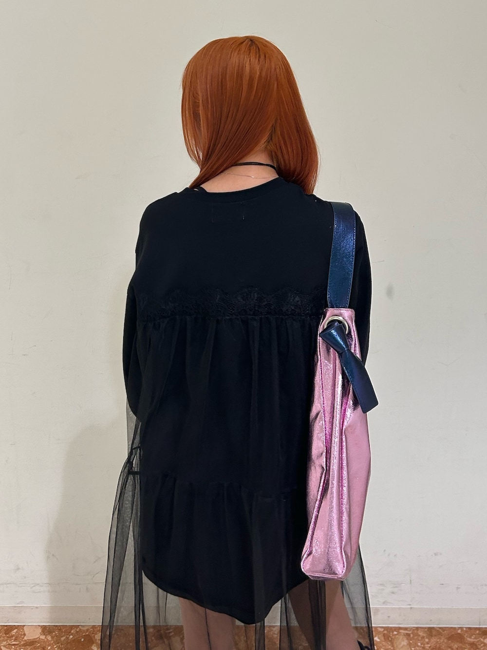 ブラック系のワンピース、ピンク系のトートバッグ、ブラック系のチョーカーを着用したレディースの春コーディネートの6枚目の写真