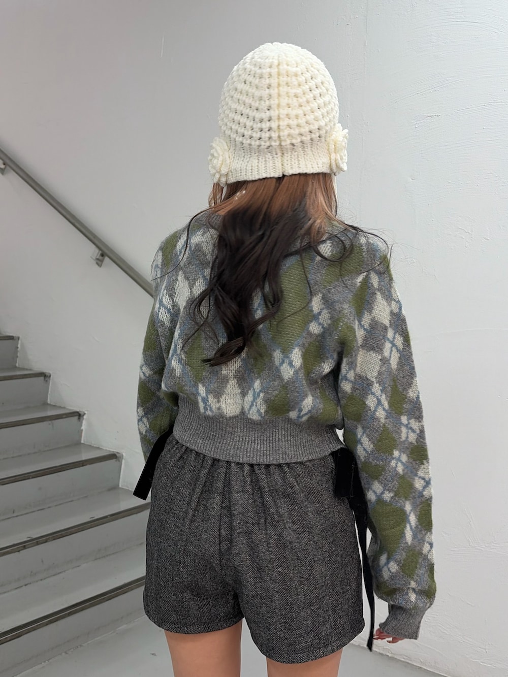 グレー系のカーディガン/ボレロ、グレー系のその他パンツ、ホワイト系のニットキャップ/ビーニーを着用したレディースの秋コーディネートの6枚目の写真