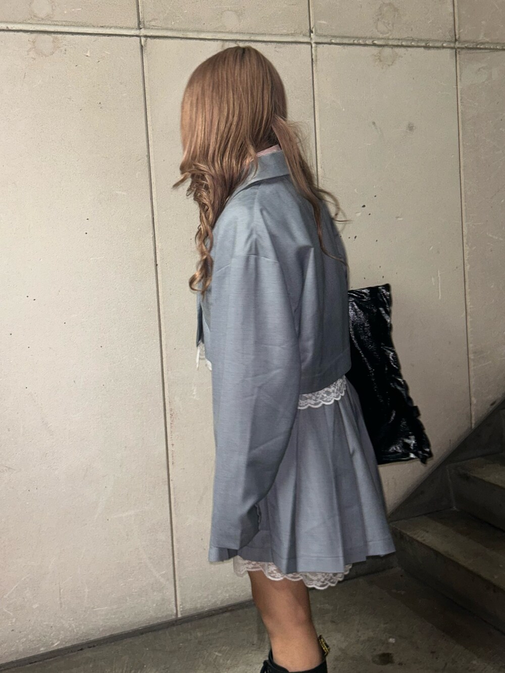 ブラック系のトートバッグ、グレー系のテーラードジャケット、グレー系のスカートを着用したレディースの冬コーディネートの7枚目の写真