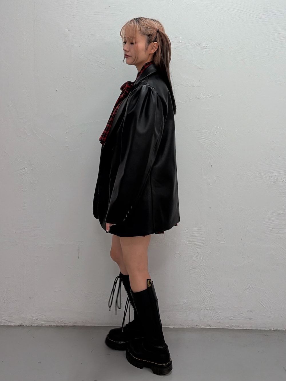 レッド系のワンピース、ブラック系のテーラードジャケットを着用したレディースの春コーディネートの2枚目の写真