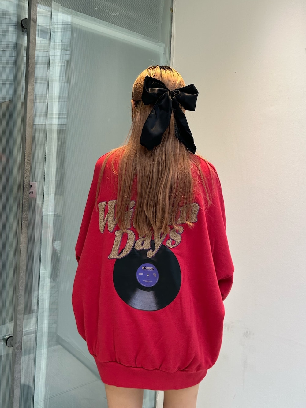 レッド系のTシャツ/カットソー、ブラック系のブーツ、ブラック系のアームカバーを着用したレディースの秋コーディネートの6枚目の写真