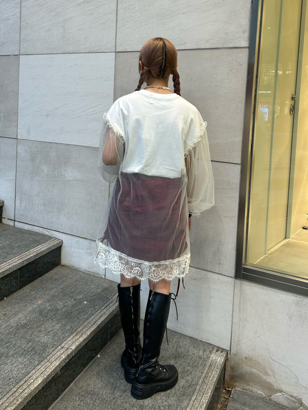レッド系のスカート、ホワイト系のワンピースを着用したレディースの夏コーディネートの2枚目の写真
