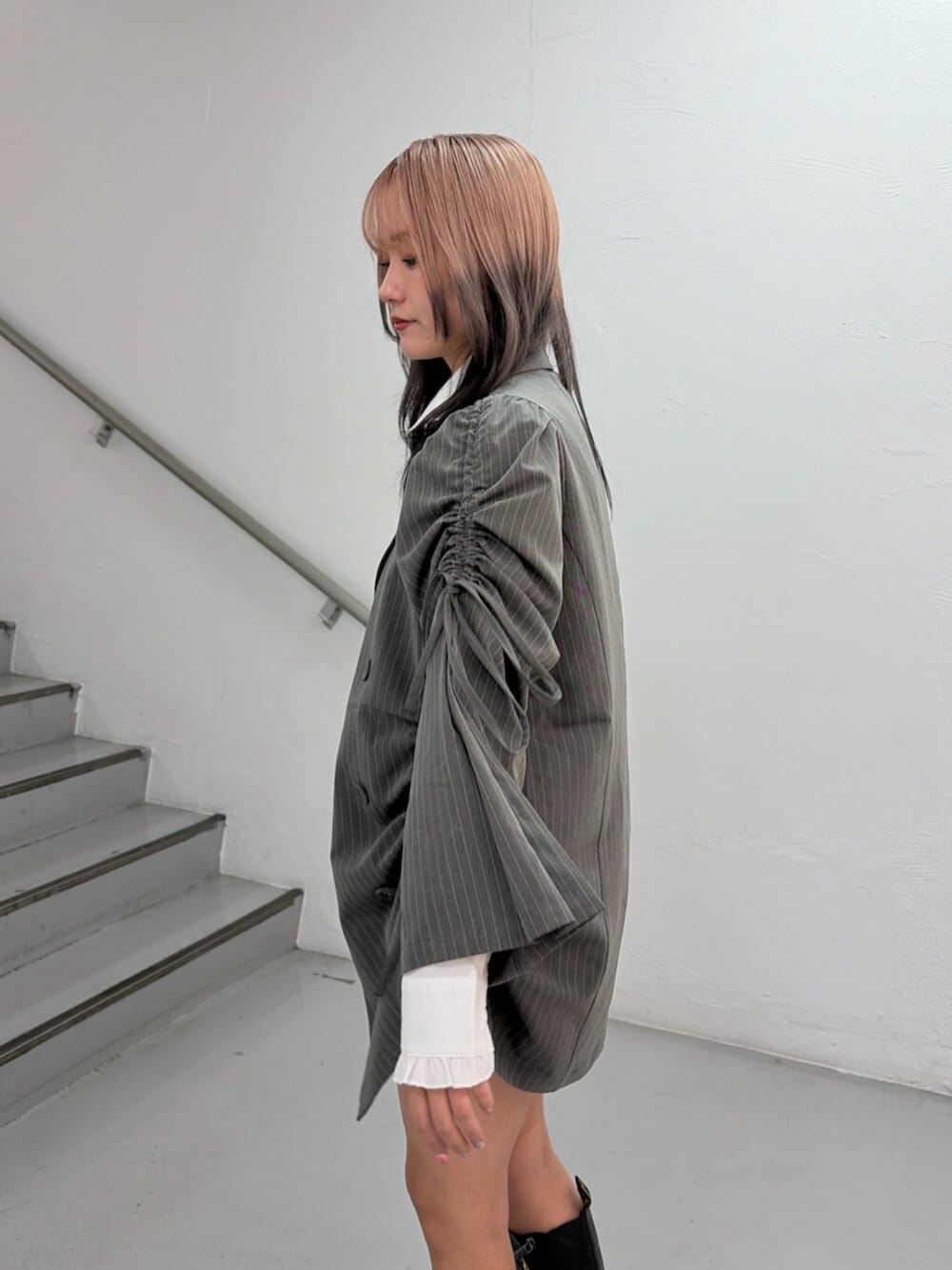 グレー系のテーラードジャケット、グレー系のスカート、ホワイト系のシャツ/ブラウスを着用したレディースの冬コーディネートの6枚目の写真