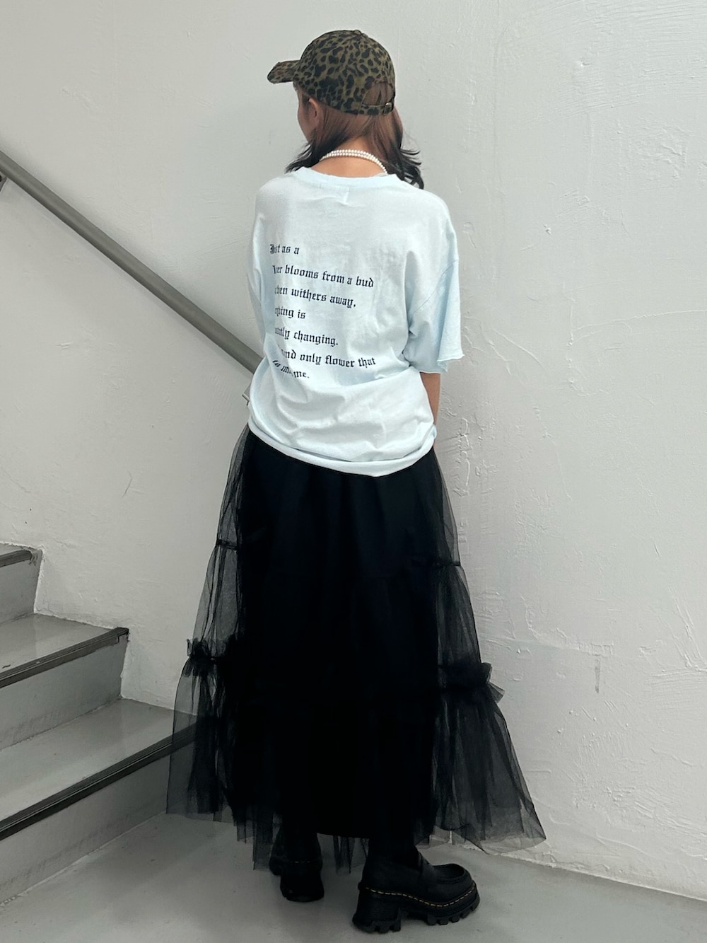 ブルー系のTシャツ/カットソー、ブラック系のスカート、ブラウン系のキャップを着用したレディースの夏コーディネートの4枚目の写真