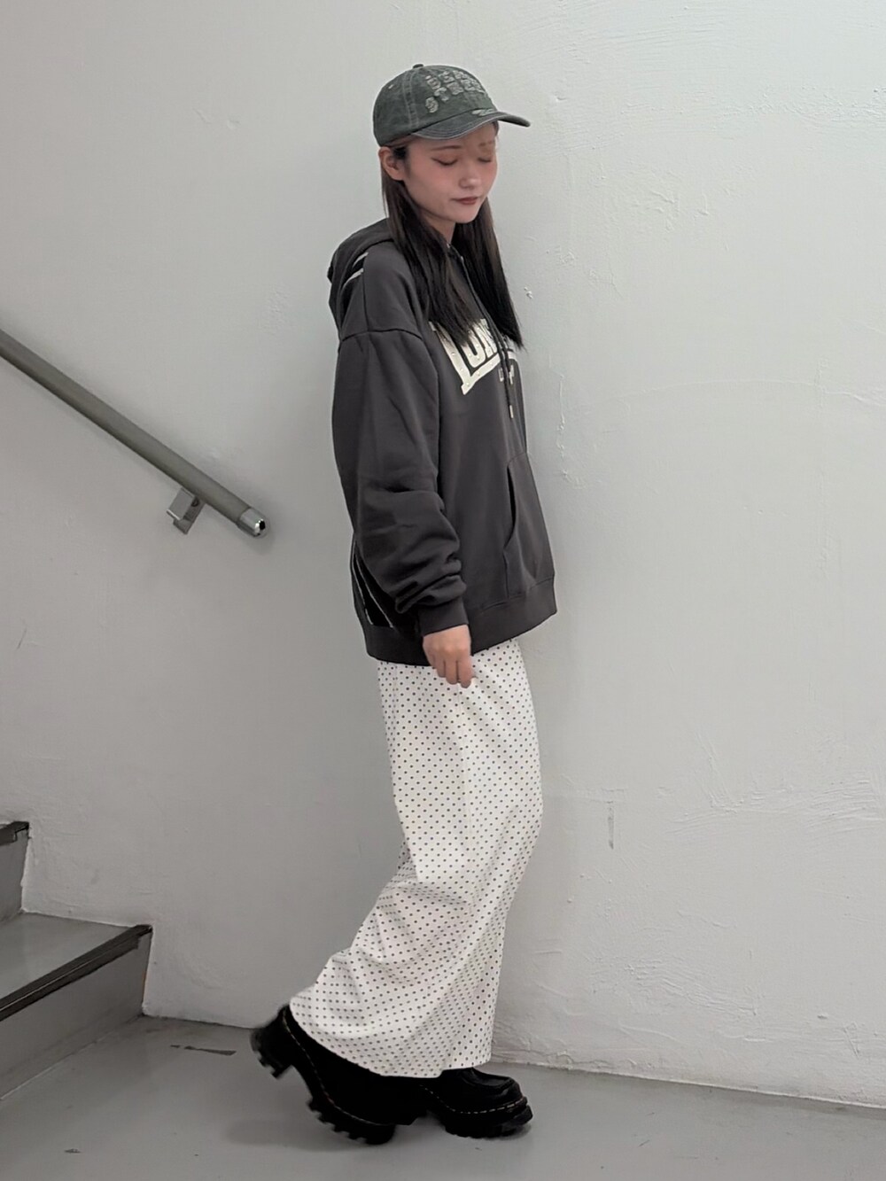 ブラック系のパーカー、ホワイト系のスウェットパンツ、ベージュ系のキャップを着用したレディースの春コーディネートの2枚目の写真
