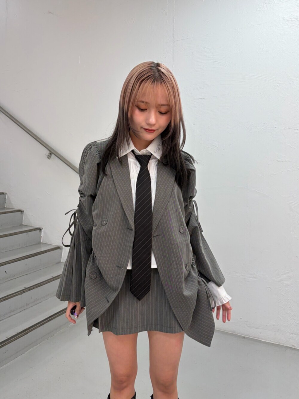 グレー系のテーラードジャケット、グレー系のスカート、ホワイト系のシャツ/ブラウスを着用したレディースの冬コーディネートの5枚目の写真