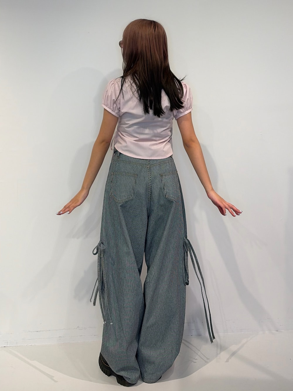 ピンク系のシャツ/ブラウス、ブルー系のデニムパンツを着用したレディースの春コーディネートの3枚目の写真