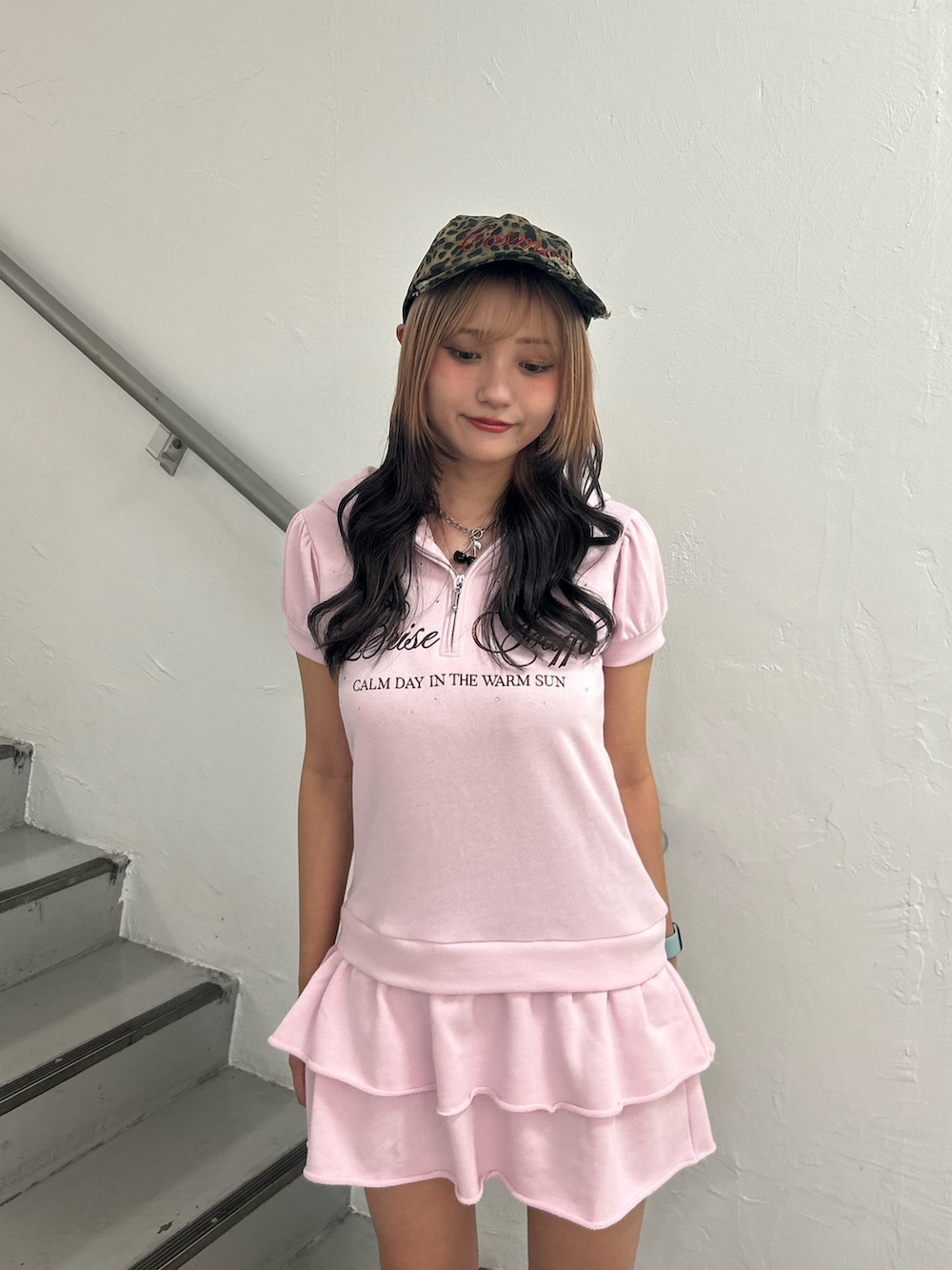 ピンク系のワンピース、ブラック系のネックレス、ブラウン系のキャップを着用したレディースの夏コーディネートの4枚目の写真