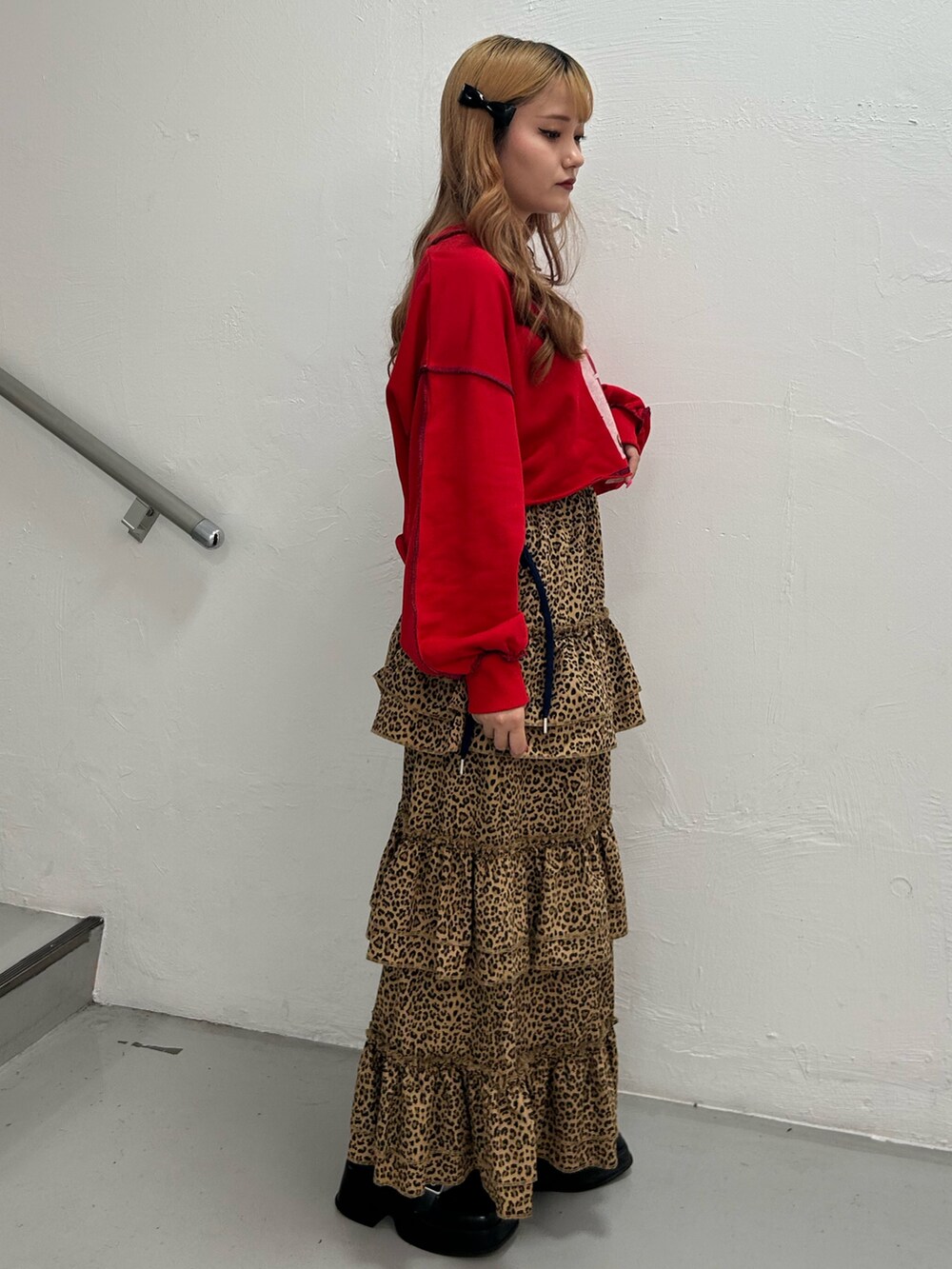 レッド系のスウェット、ブラウン系のスカート、ブラック系のバレエシューズを着用したレディースの夏コーディネートの3枚目の写真