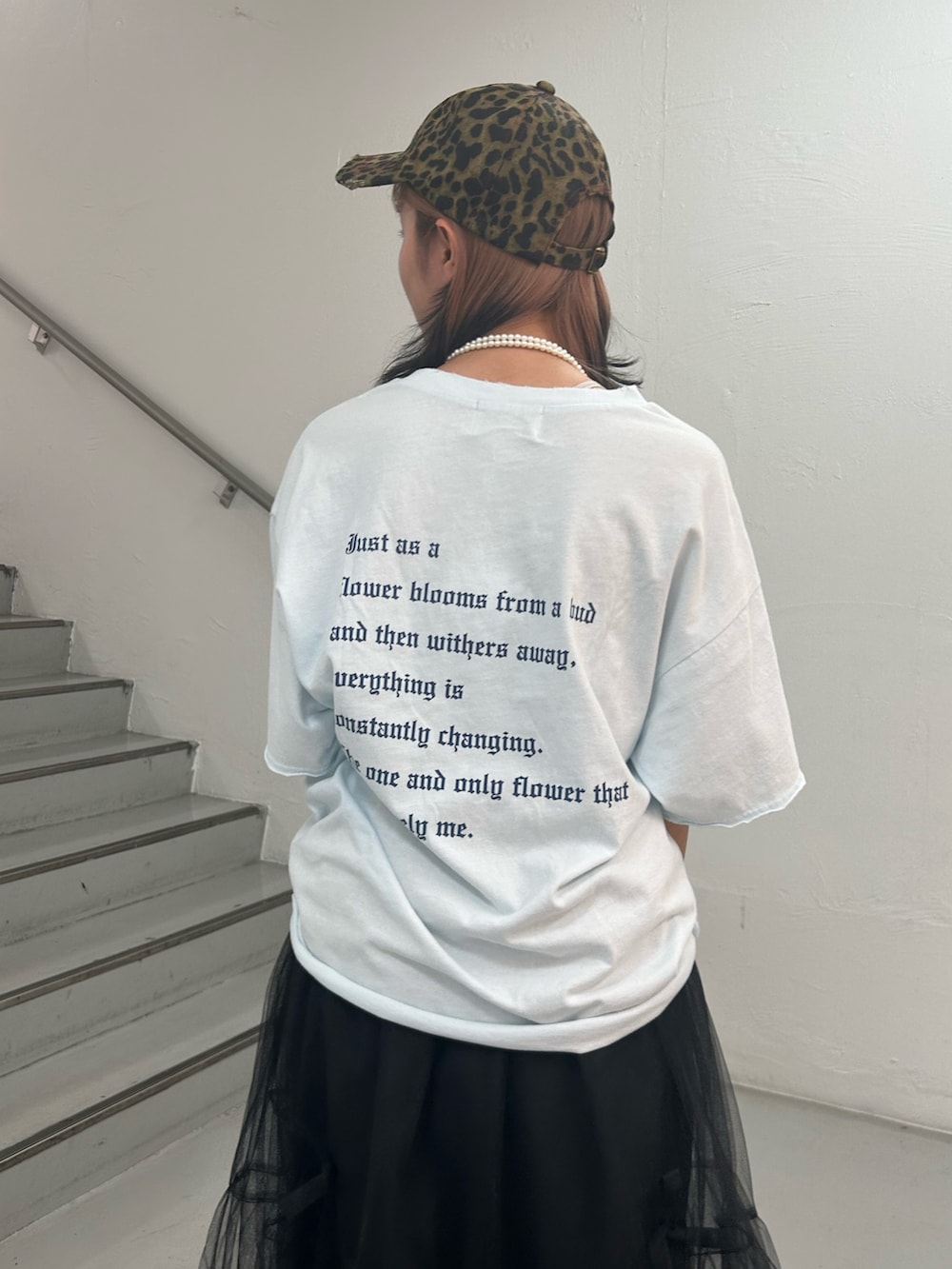 ブルー系のTシャツ/カットソー、ブラック系のスカート、ブラウン系のキャップを着用したレディースの夏コーディネートの7枚目の写真