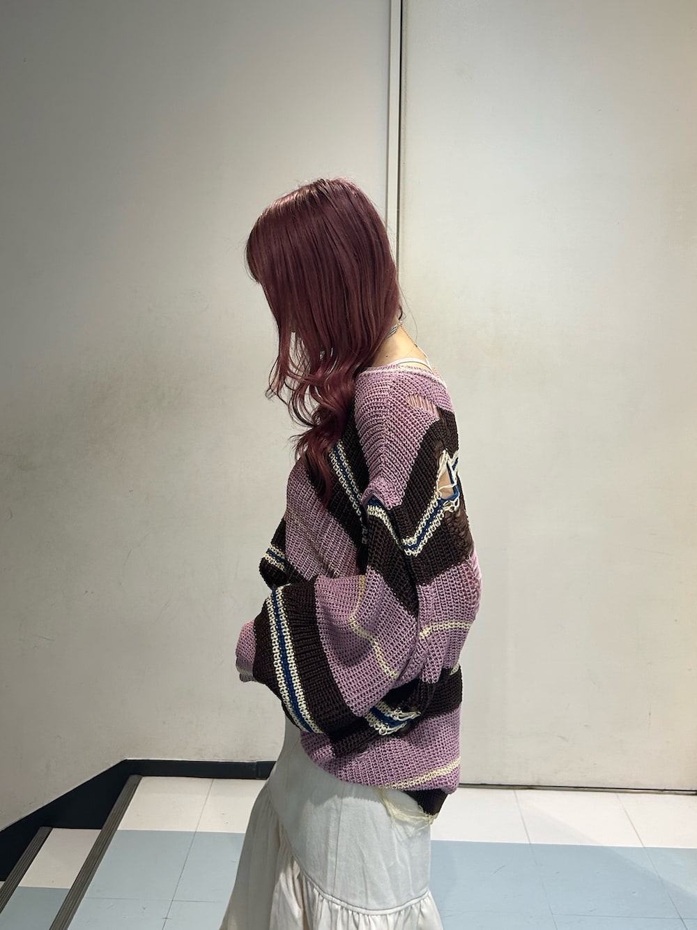 ピンク系のニット/セーター、ホワイト系のワンピース、ブラック系のブーツを着用したレディースの春コーディネートの5枚目の写真