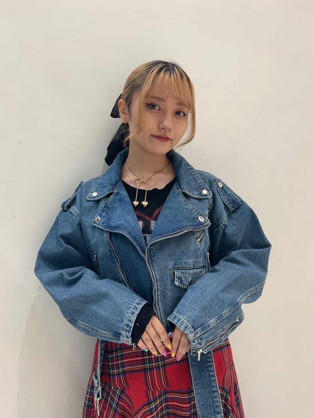レッド系のスカート、ブラック系のTシャツ/カットソー、ブルー系のライダースジャケットを着用したレディースの秋コーディネートの4枚目の写真
