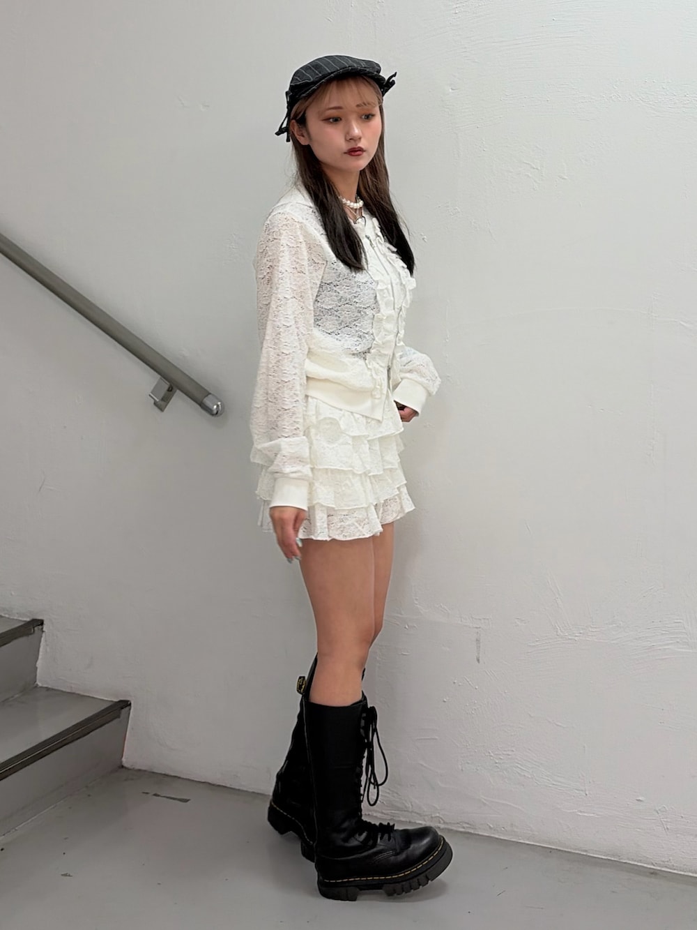 ホワイト系のパーカー、ホワイト系のスカート、グレー系のハンチング/ベレー帽を着用したレディースの春コーディネートの2枚目の写真