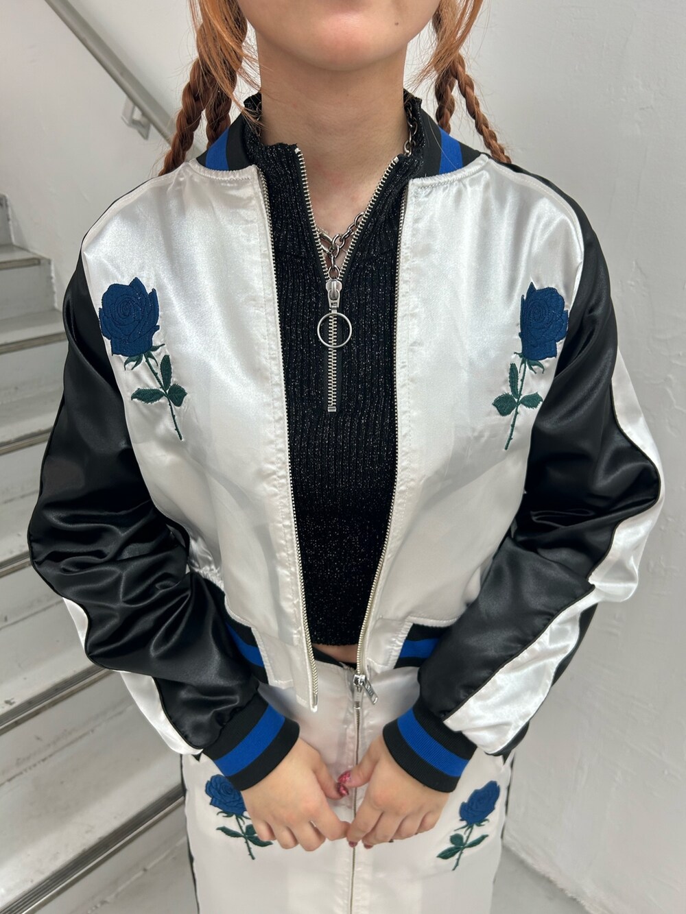 ホワイト系のスカジャン、ブラック系のニット/セーター、ホワイト系のスカートを着用したレディースの春コーディネートの7枚目の写真