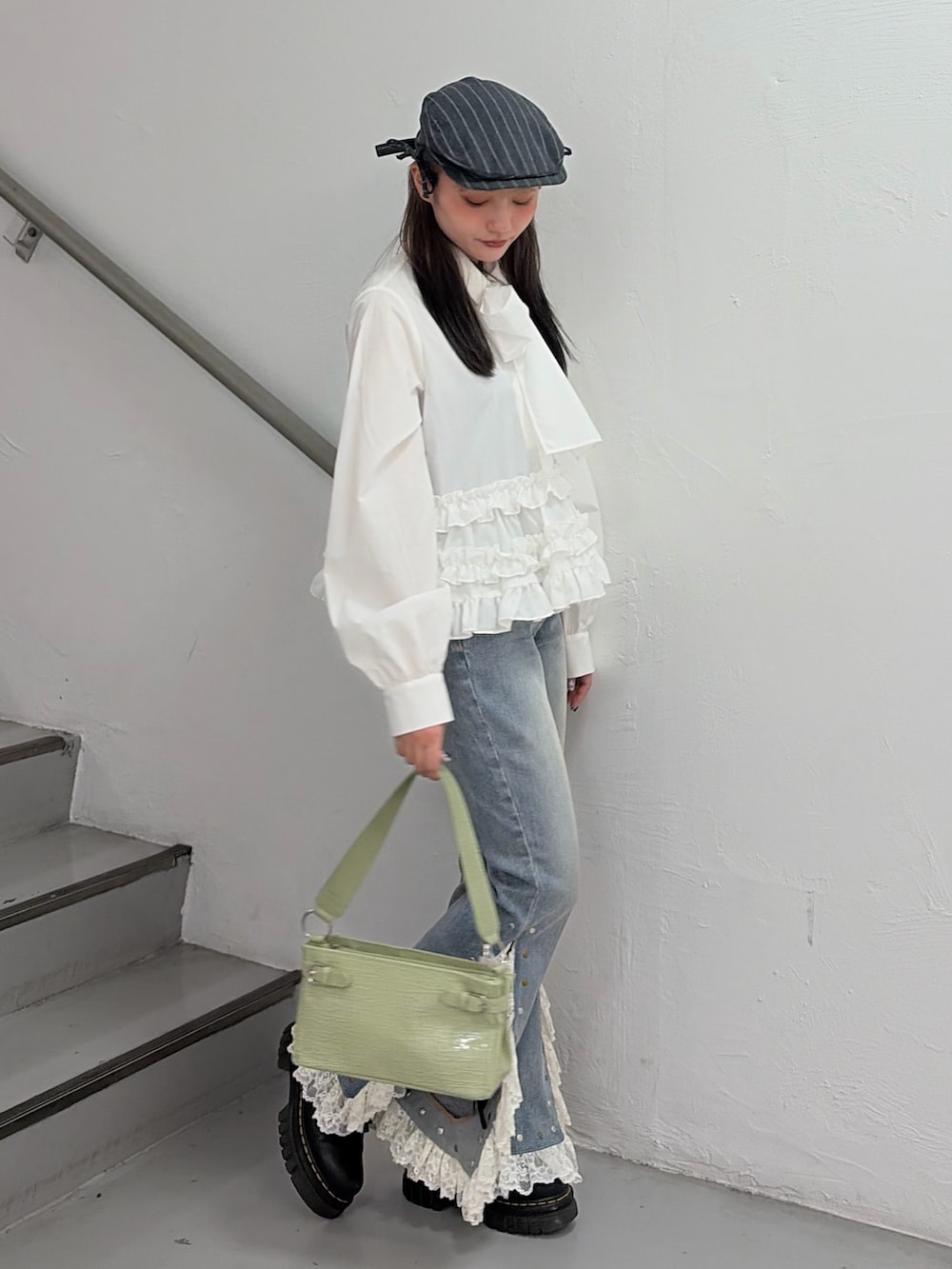 ホワイト系のシャツ/ブラウス、ブルー系のデニムパンツ、グリーン系のハンドバッグを着用したレディースの冬コーディネートの3枚目の写真