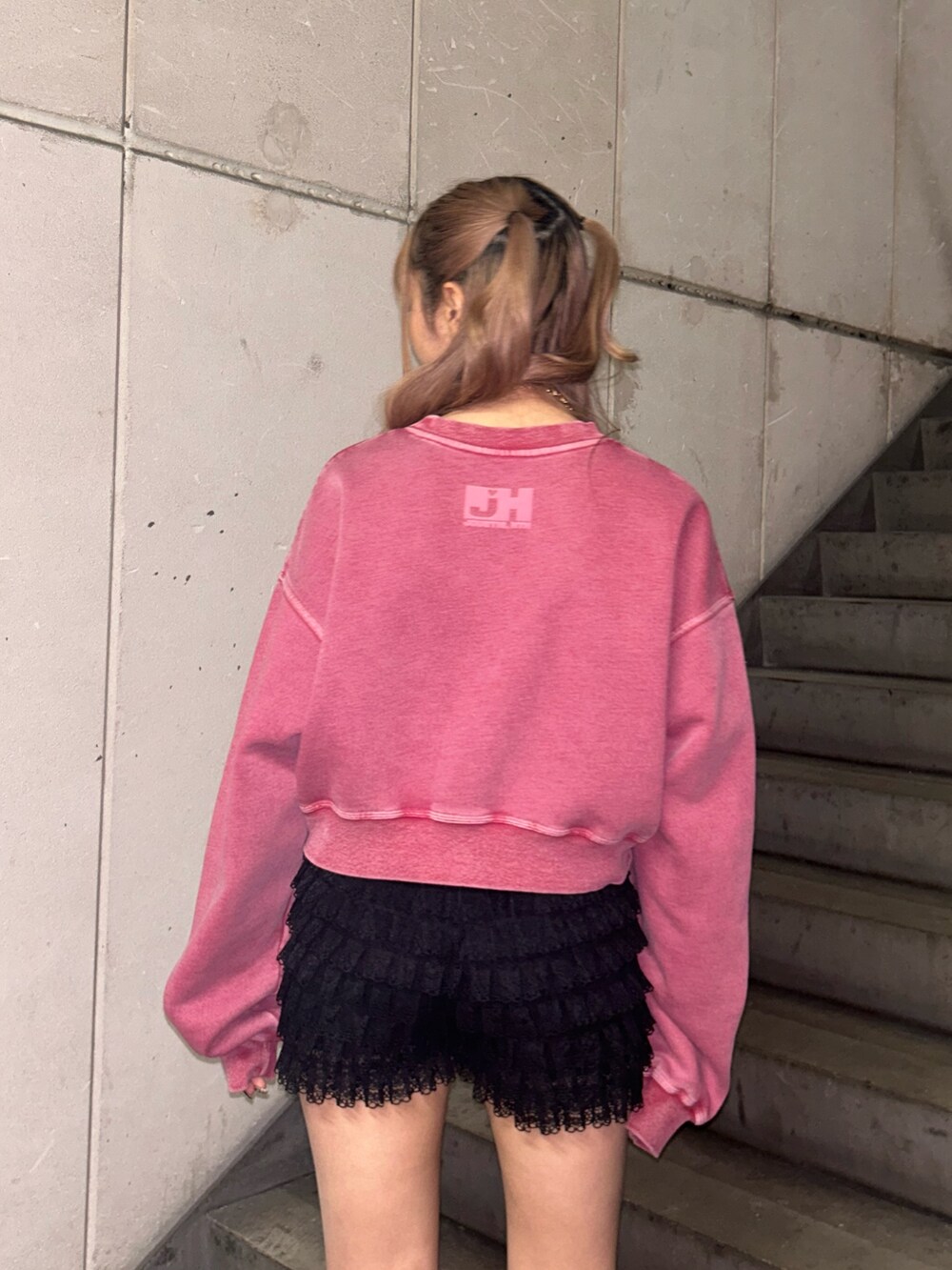 ピンク系のスウェット、ブラック系のその他パンツ、ゴールド系のネックレスを着用したレディースの冬コーディネートの6枚目の写真