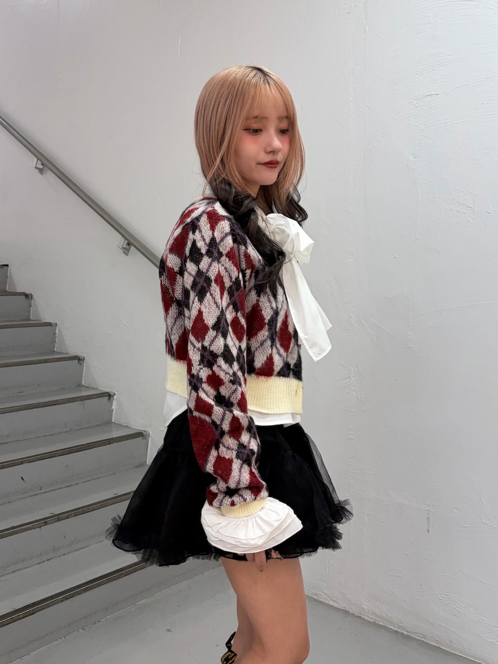 ホワイト系のカーディガン/ボレロ、ホワイト系のシャツ/ブラウス、ブラック系のスカートを着用したレディースの秋コーディネートの5枚目の写真