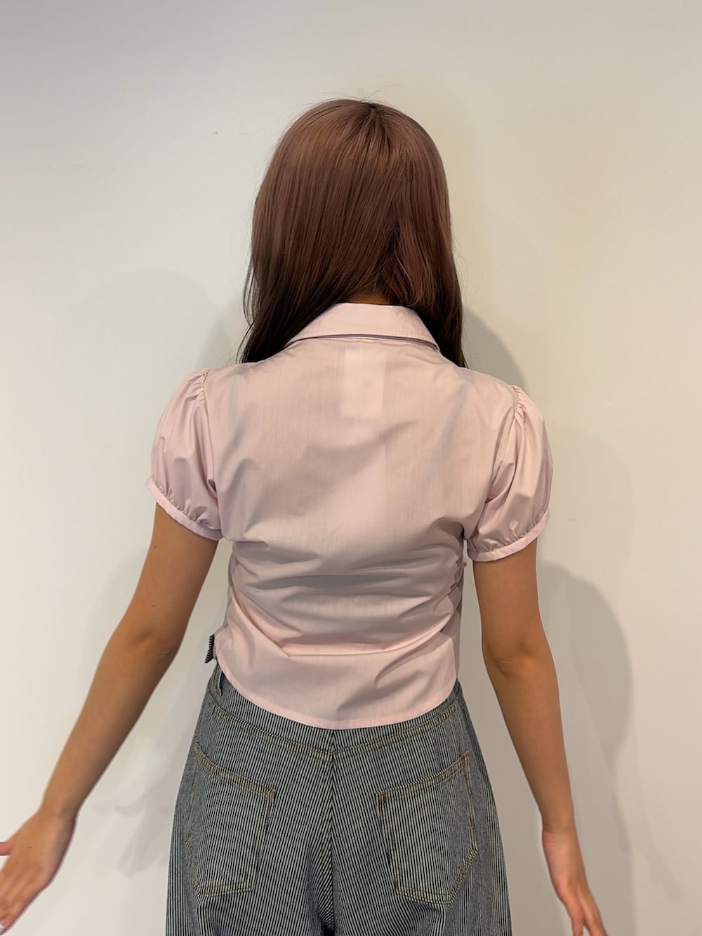 ピンク系のシャツ/ブラウス、ブルー系のデニムパンツを着用したレディースの春コーディネートの5枚目の写真