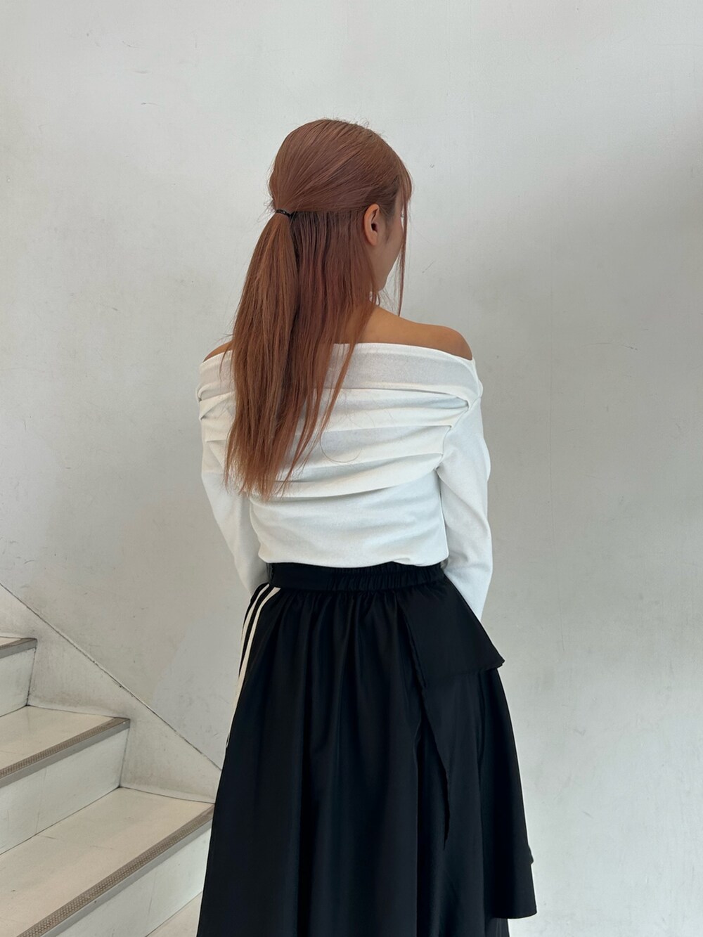 ホワイト系のTシャツ/カットソー、ブラック系のスカート、ブラック系のハンドバッグを着用したレディースの春コーディネートの6枚目の写真