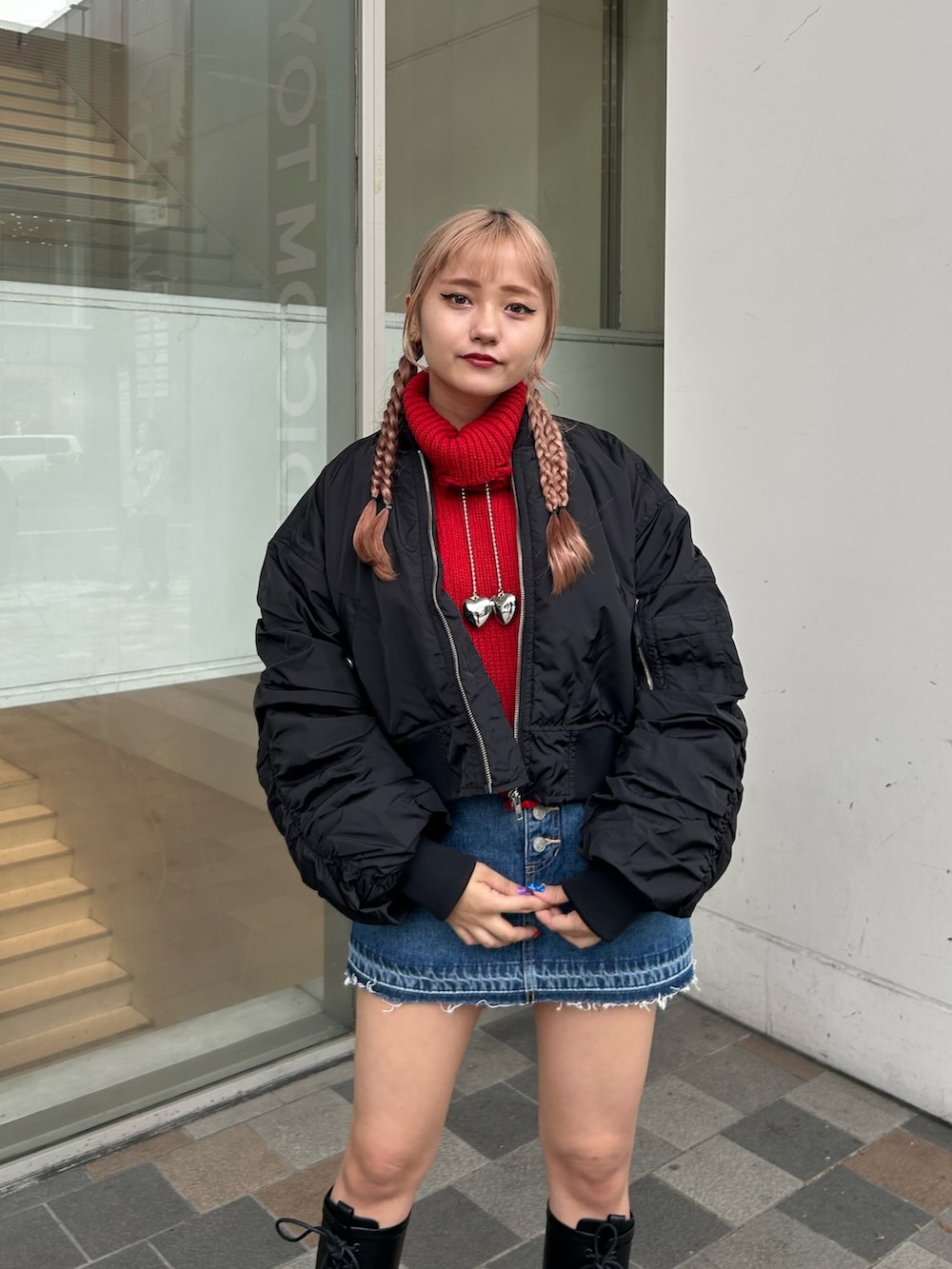 ブルー系のデニムパンツ、ブラック系のMA-1、レッド系のニット/セーターを着用したレディースの秋コーディネートの4枚目の写真