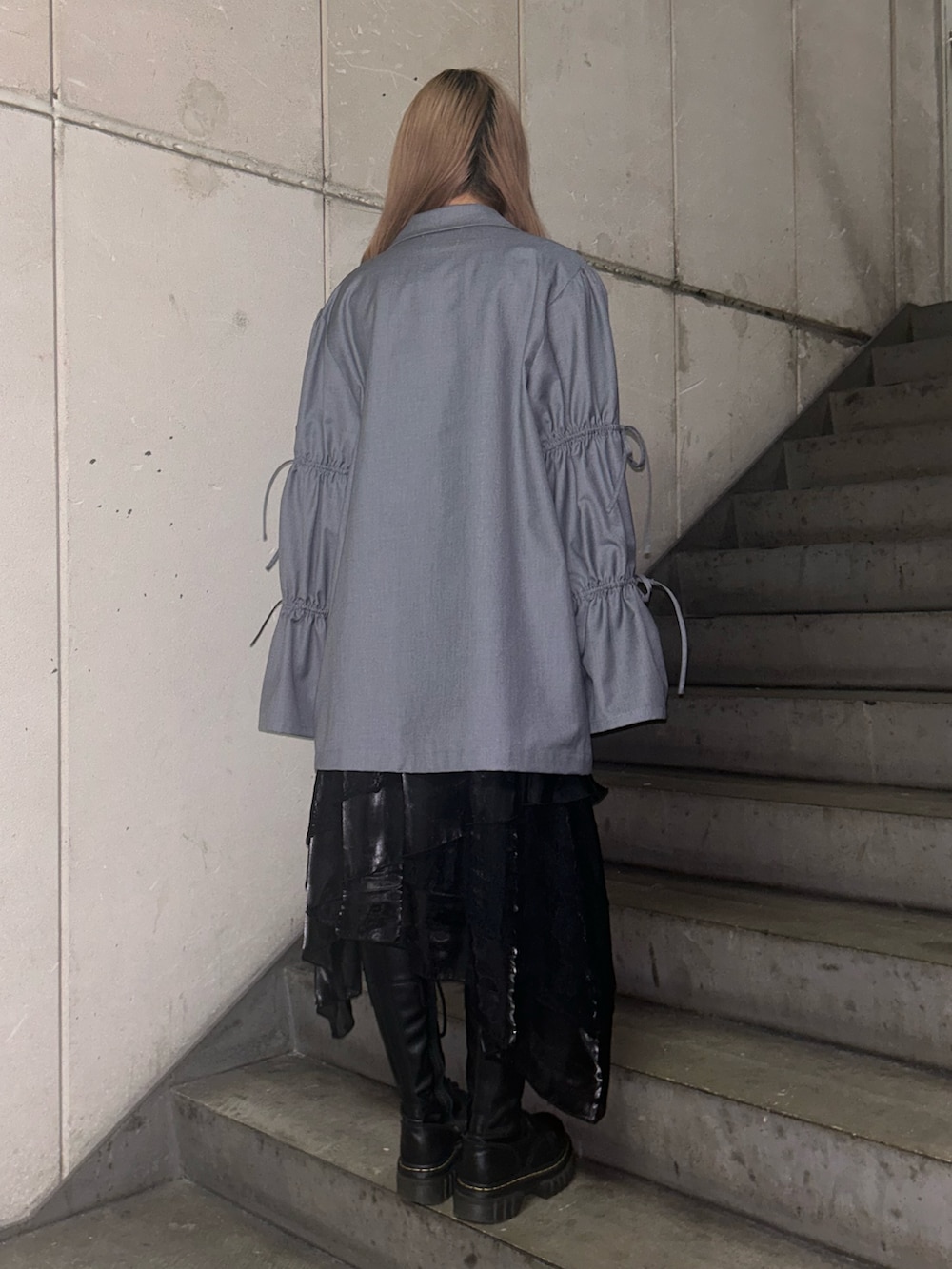 グレー系のテーラードジャケット、ブラック系のTシャツ/カットソー、ブラック系のスカートを着用したレディースの冬コーディネートの3枚目の写真