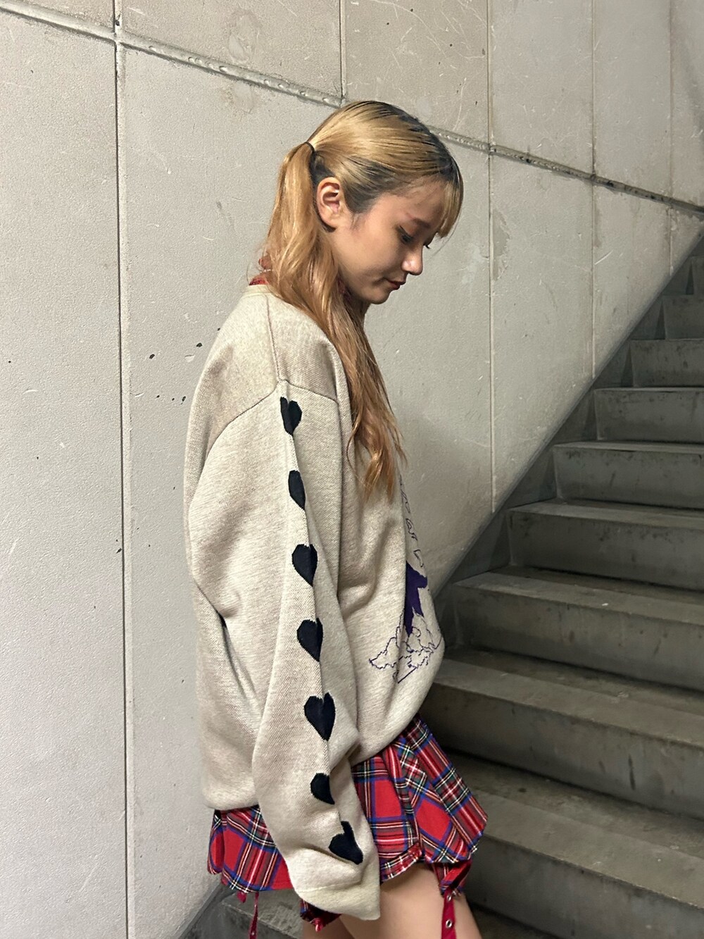 ホワイト系のニット/セーター、レッド系のスカート、レッド系のTシャツ/カットソーを着用したレディースの秋コーディネートの5枚目の写真