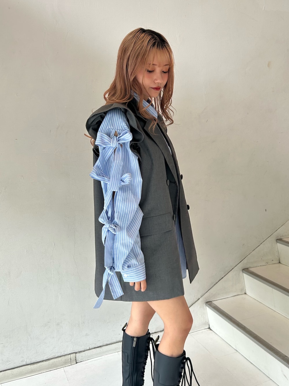 グレー系のワンピース、ブルー系のシャツ/ブラウス、シルバー系のネックレスを着用したレディースの春コーディネートの5枚目の写真