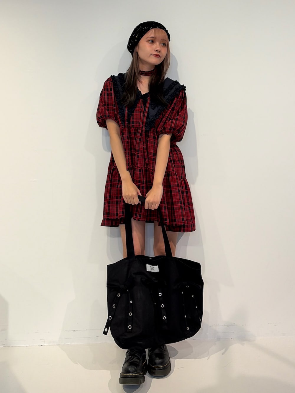 レッド系のワンピース、ブラック系のトートバッグを着用したレディースの冬コーディネートの4枚目の写真