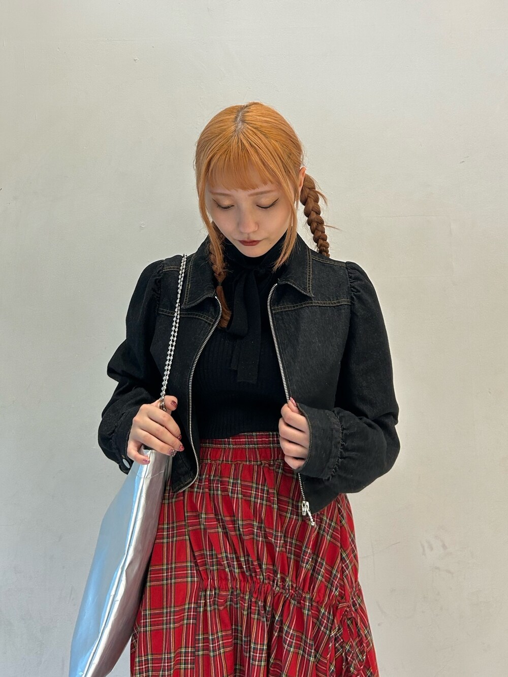 ブラック系のニット/セーター、ブラック系のワンピース、レッド系のスカートを着用したレディースの春コーディネートの4枚目の写真