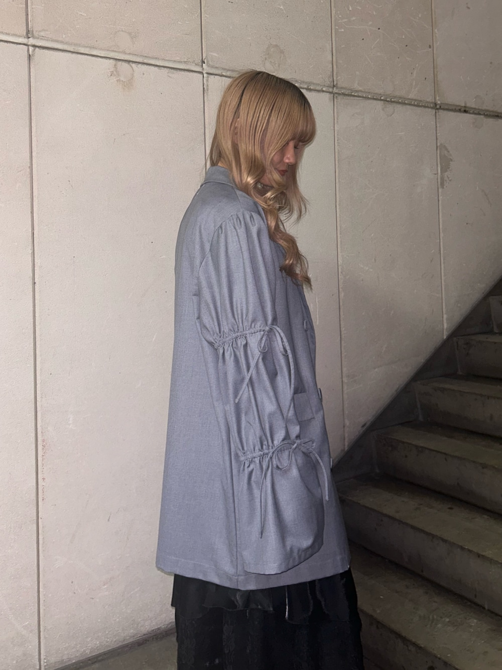 グレー系のテーラードジャケット、ブラック系のTシャツ/カットソー、ブラック系のスカートを着用したレディースの冬コーディネートの5枚目の写真