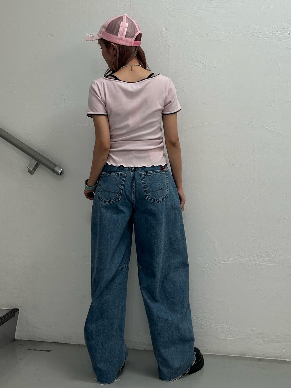 ピンク系のTシャツ/カットソー、ブルー系のデニムパンツ、ピンク系のキャップを着用したレディースの春コーディネートの3枚目の写真