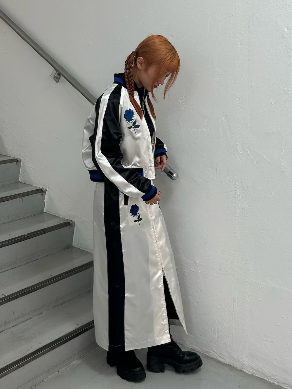 ホワイト系のスカジャン、ブラック系のニット/セーター、ホワイト系のスカートを着用したレディースの春コーディネートの2枚目の写真