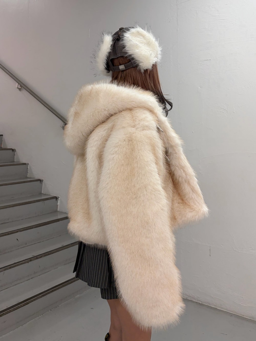 ホワイト系のブルゾン、ホワイト系のニット/セーター、グレー系のスカートを着用したレディースの秋コーディネートの5枚目の写真