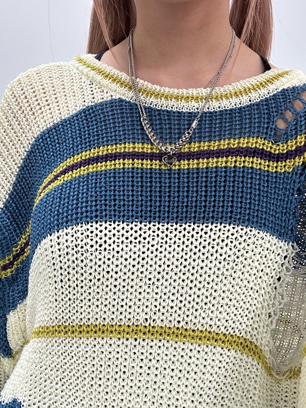 ホワイト系のニット/セーター、ブルー系のデニムスカート、ブラック系のブーツを着用したレディースの春コーディネートの7枚目の写真