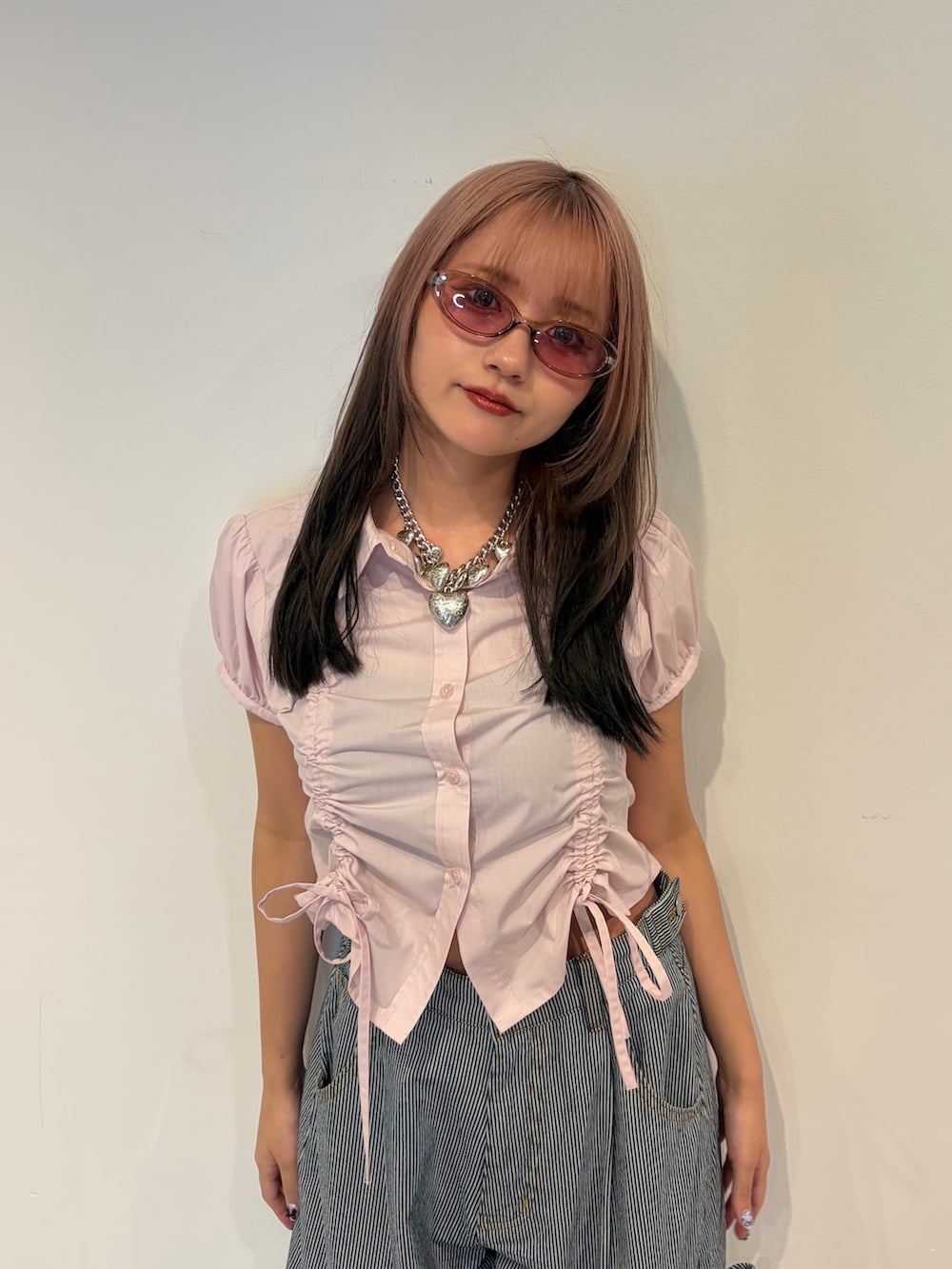 ピンク系のシャツ/ブラウス、ブルー系のデニムパンツを着用したレディースの春コーディネートの4枚目の写真