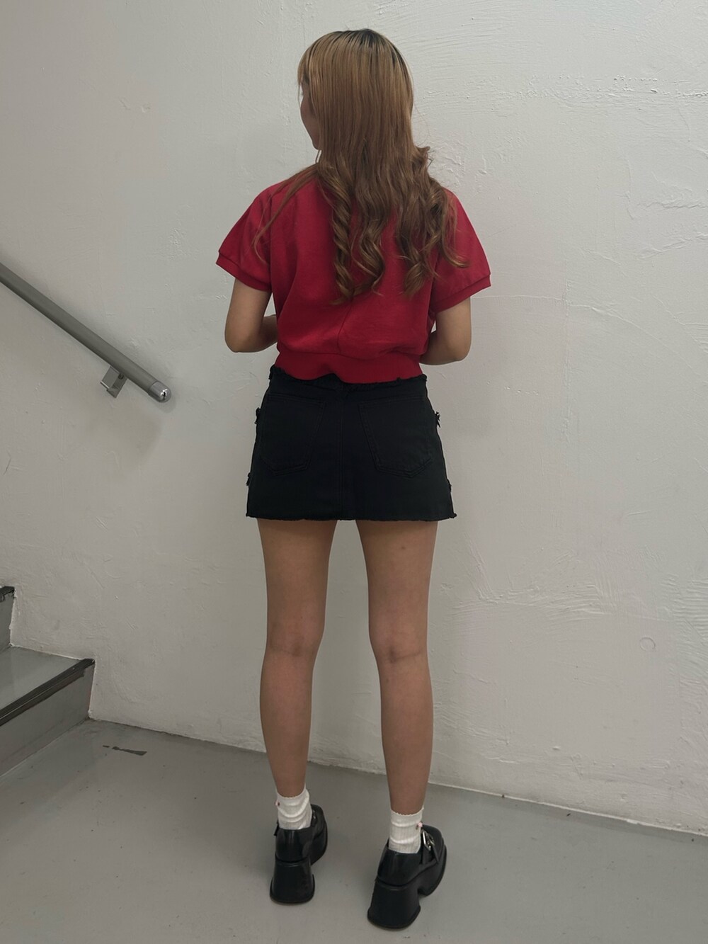 レッド系のTシャツ/カットソー、ブラック系のスカート、ブラック系のバレエシューズを着用したレディースの夏コーディネートの3枚目の写真