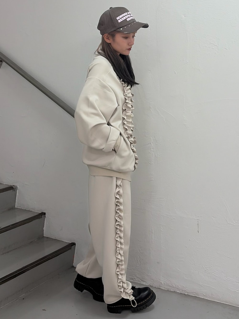 ホワイト系のジャージ、ホワイト系のその他パンツ、ブラウン系のキャップを着用したレディースの冬コーディネートの2枚目の写真