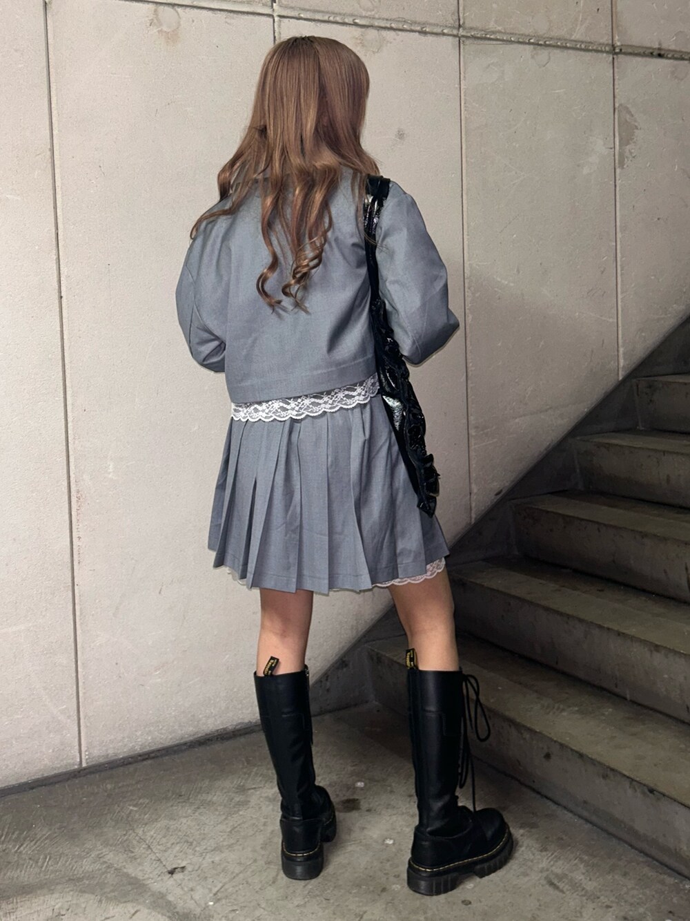 ブラック系のトートバッグ、グレー系のテーラードジャケット、グレー系のスカートを着用したレディースの冬コーディネートの4枚目の写真