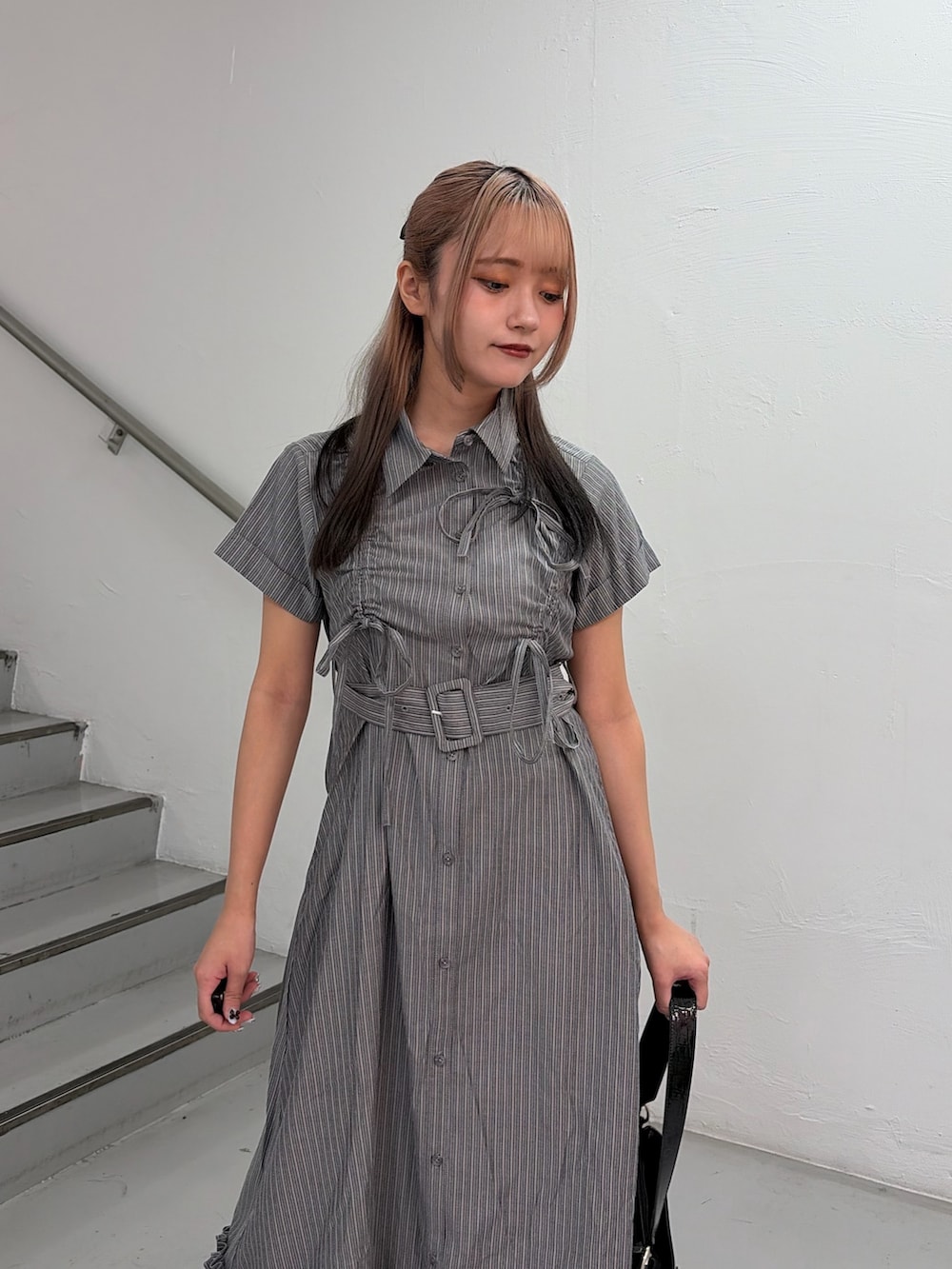 グレー系のワンピース、ブラック系のハンドバッグを着用したレディースの春コーディネートの5枚目の写真