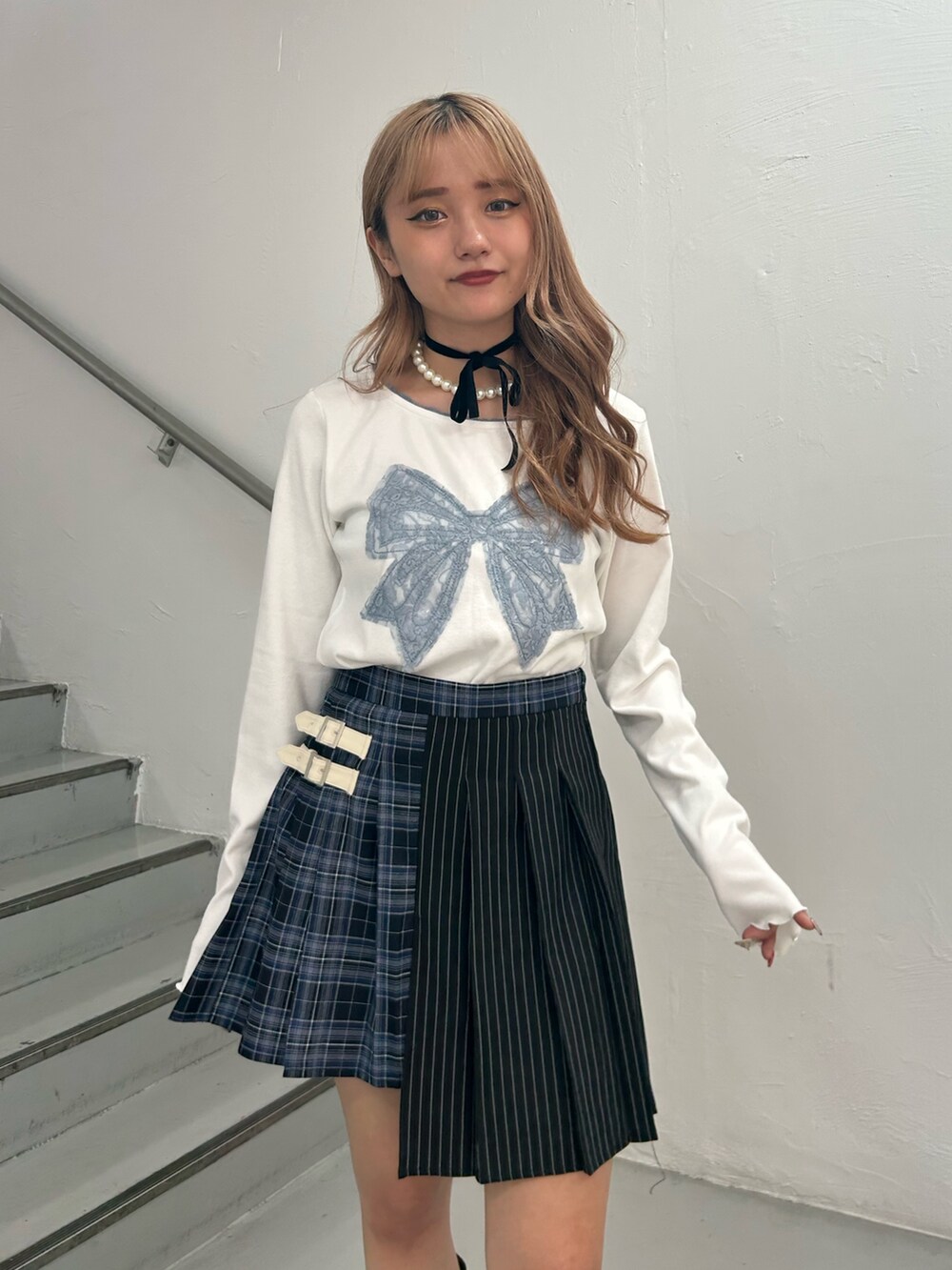 ホワイト系のTシャツ/カットソー、ブルー系のスカート、ブラウン系のブーツを着用したレディースの秋コーディネートの4枚目の写真