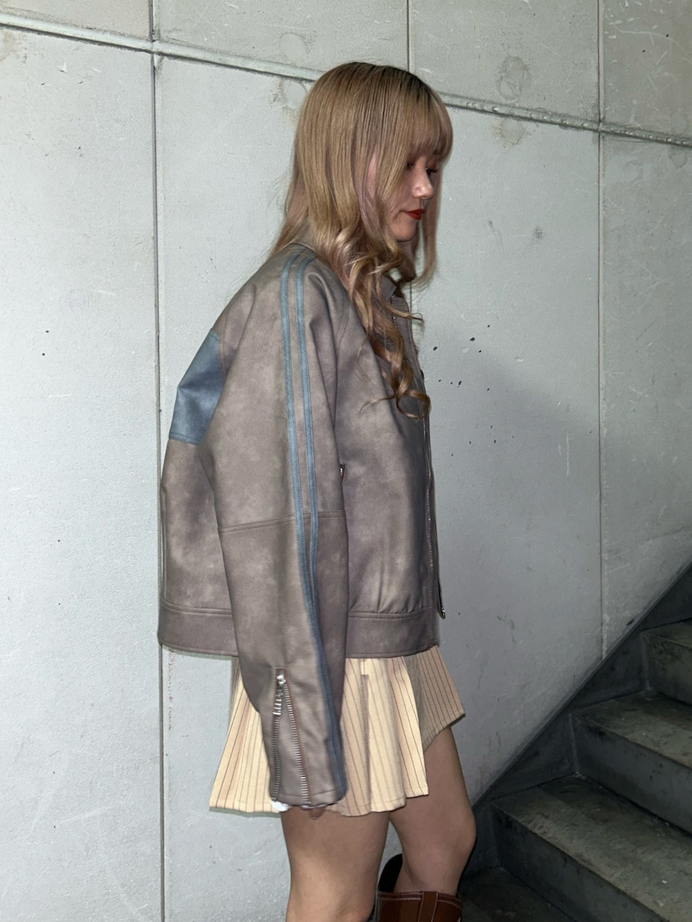 ブラウン系のブルゾン、ホワイト系のTシャツ/カットソー、ベージュ系のスカートを着用したレディースの冬コーディネートの5枚目の写真