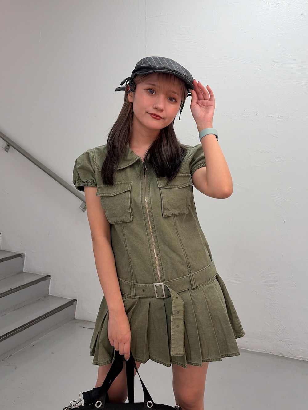 グリーン系のワンピース、ブラック系のボストンバッグ、グレー系のハンチング/ベレー帽を着用したレディースの冬コーディネートの4枚目の写真