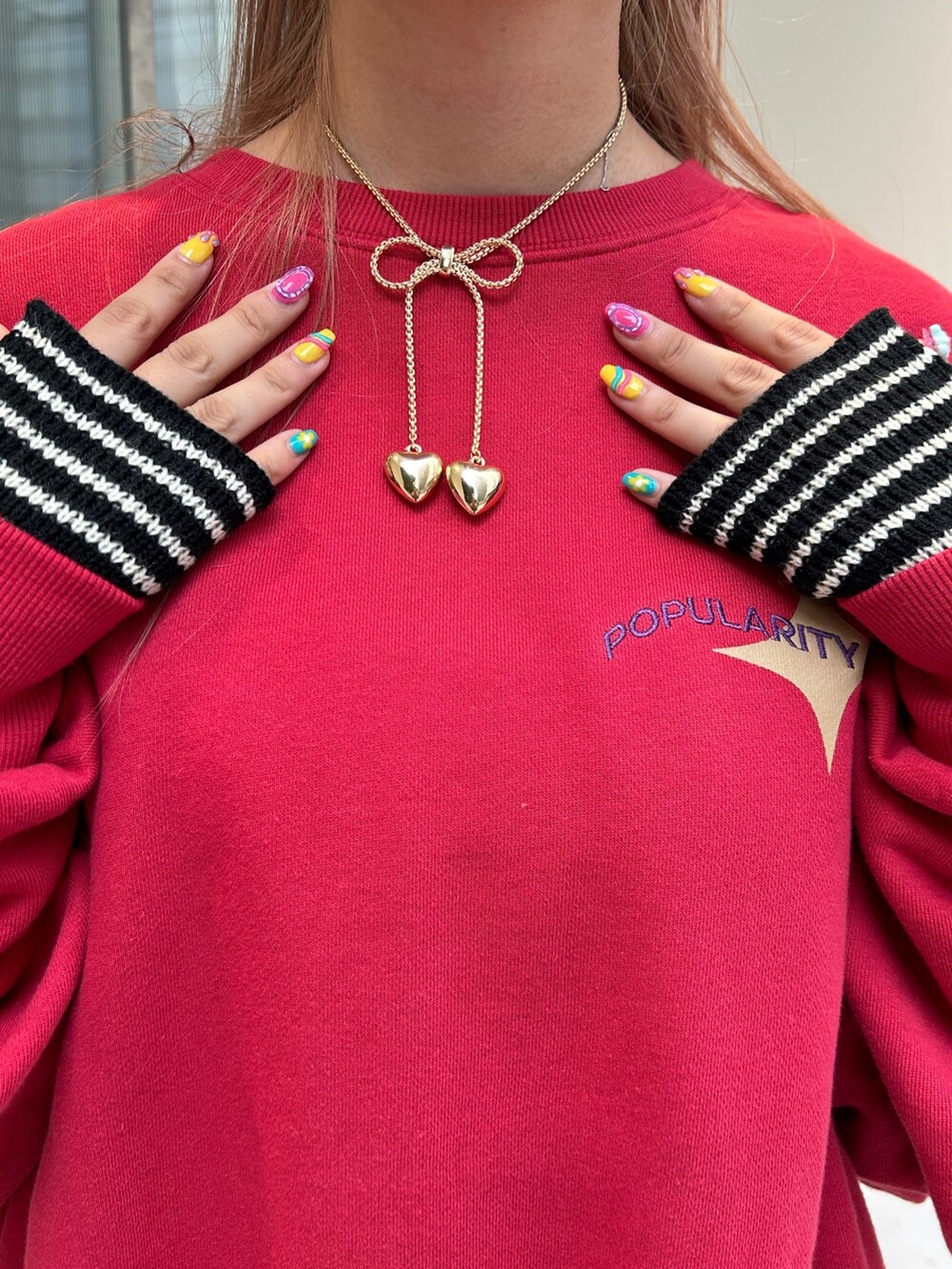レッド系のTシャツ/カットソー、ブラック系のブーツ、ブラック系のアームカバーを着用したレディースの秋コーディネートの8枚目の写真