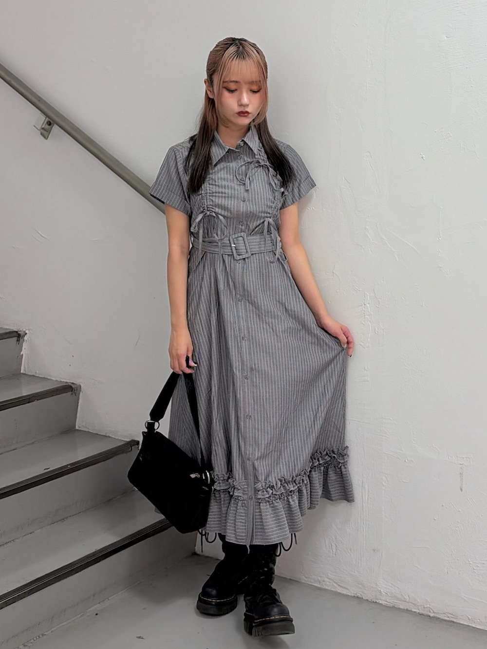 グレー系のワンピース、ブラック系のハンドバッグを着用したレディースの春コーディネートの2枚目の写真