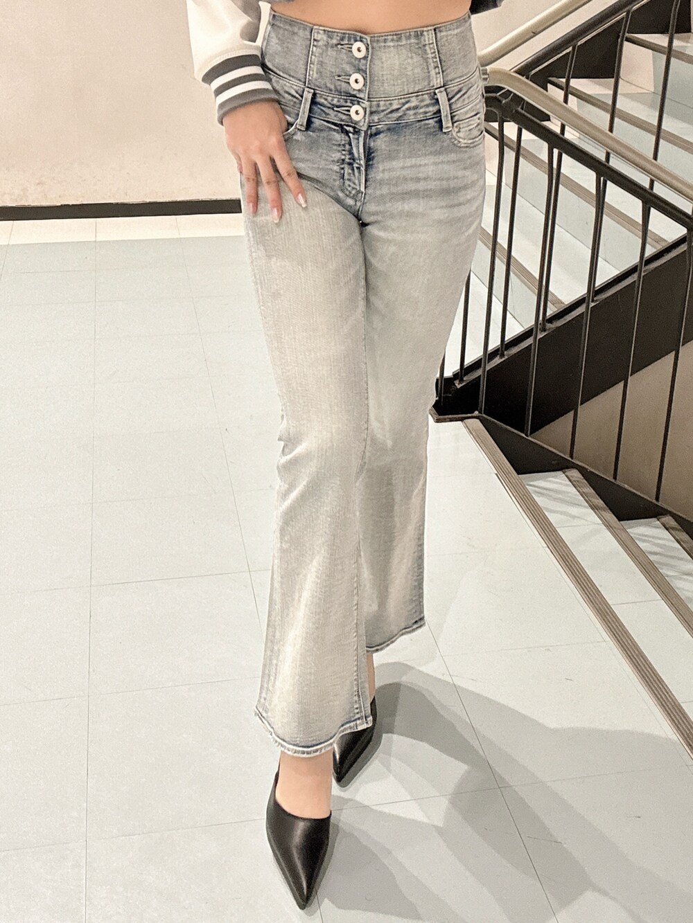 ブラック系のパンプス、グレー系のブルゾン、ホワイト系のキャミソールを着用したレディースの冬コーディネートの6枚目の写真