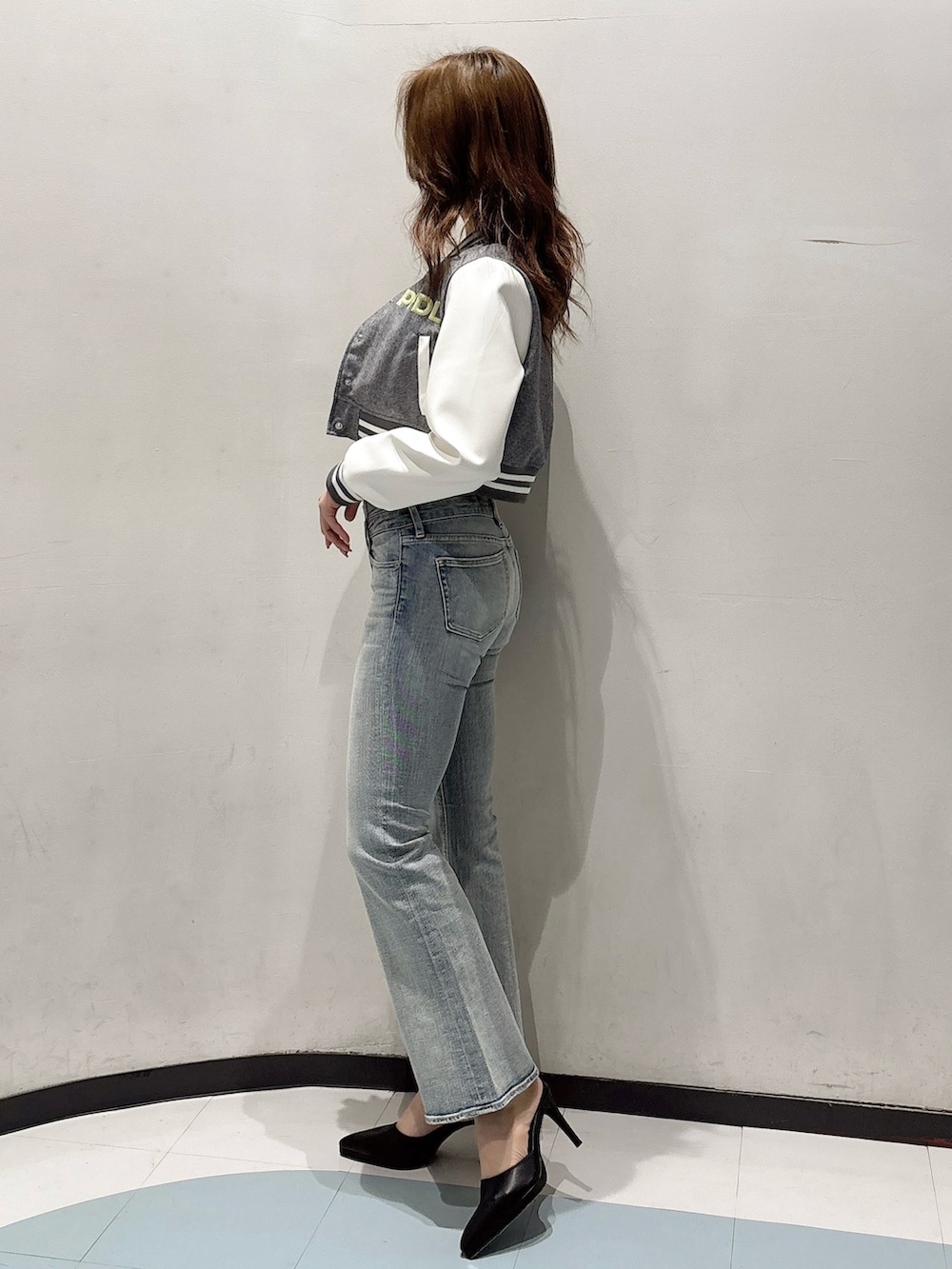 ブラック系のパンプス、グレー系のブルゾン、ホワイト系のキャミソールを着用したレディースの冬コーディネートの2枚目の写真