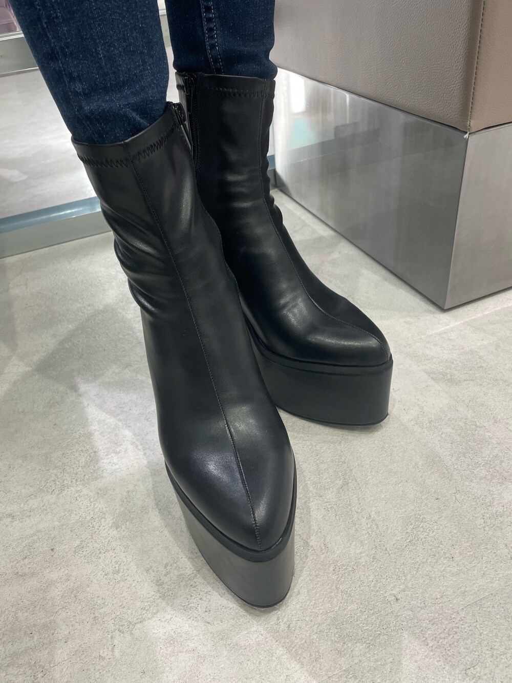 ブラック系のワンピース、ホワイト系のハンドバッグ、ブルー系のデニムパンツを着用したレディースの秋コーディネートの6枚目の写真
